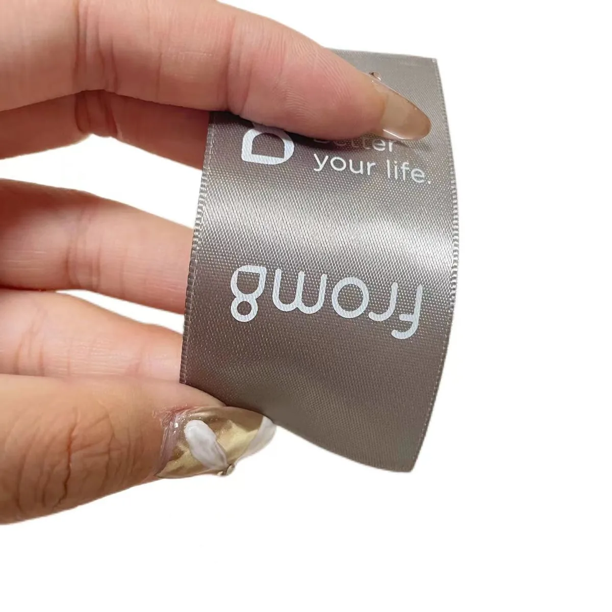 Gray satin center-fold garment label with white logo printing