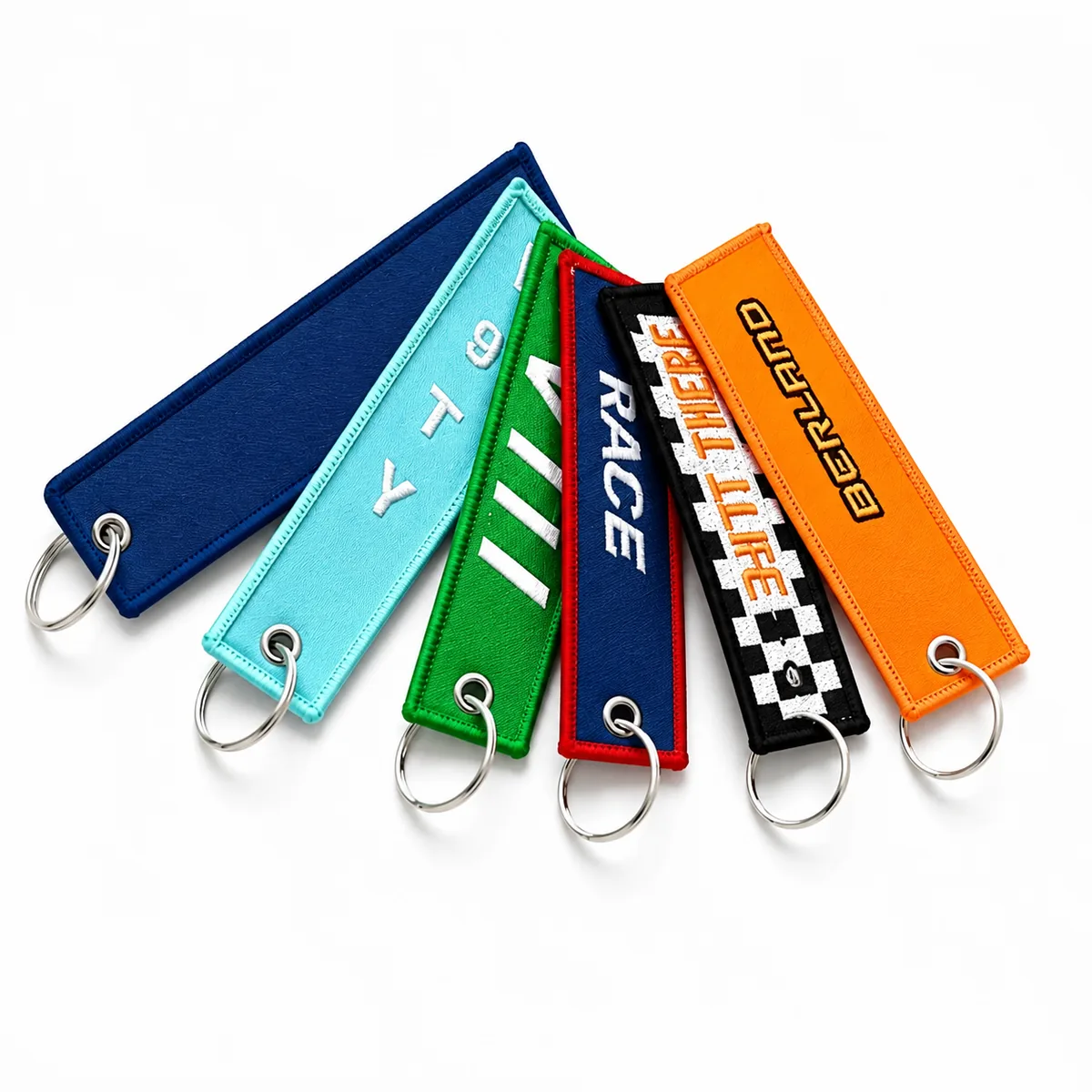 Assorted colorful embroidered jet tag keychains with metal rings