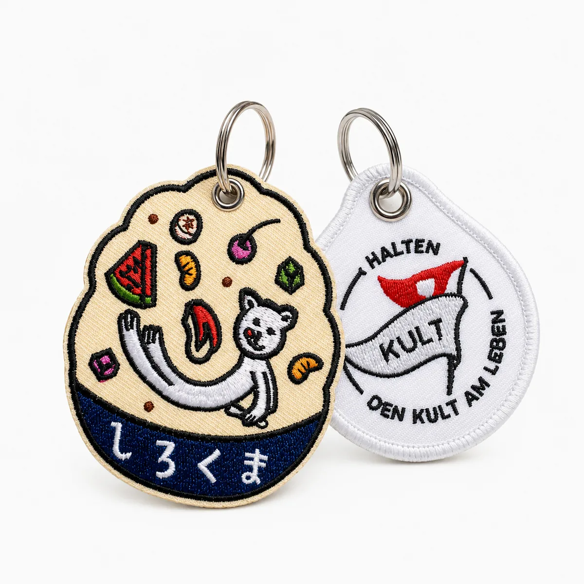 Round embroidered character keychain pair with metal rings