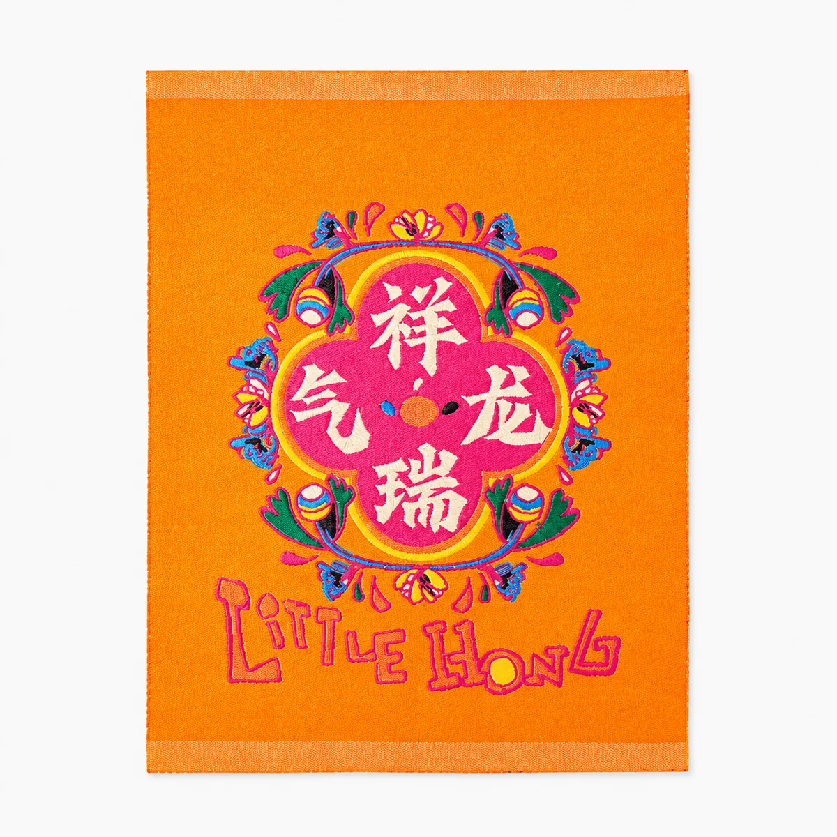 Colorful embroidered Little Hong brand label with a dragon motif on orange