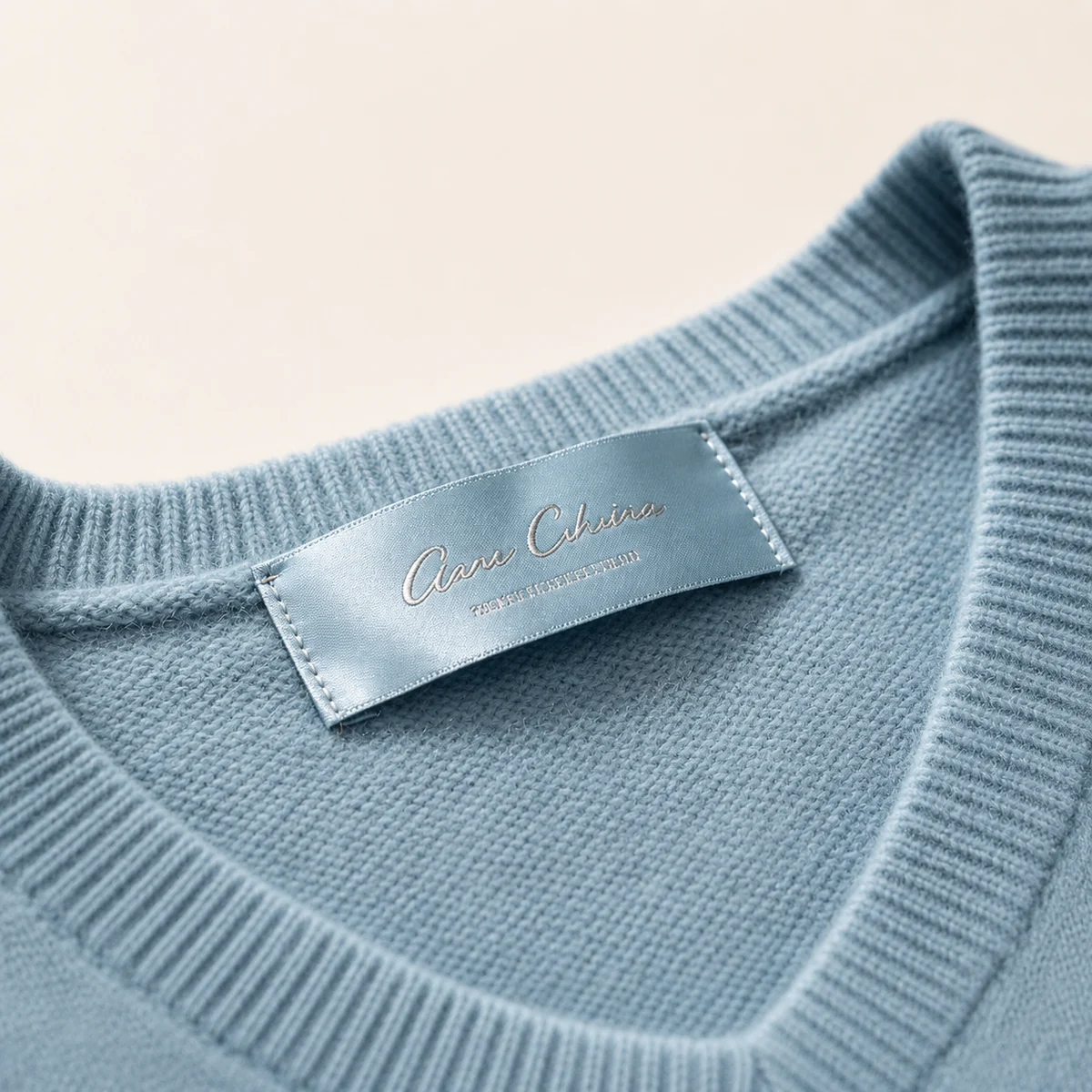 Blue satin woven neck label sewn into a knit sweater collar