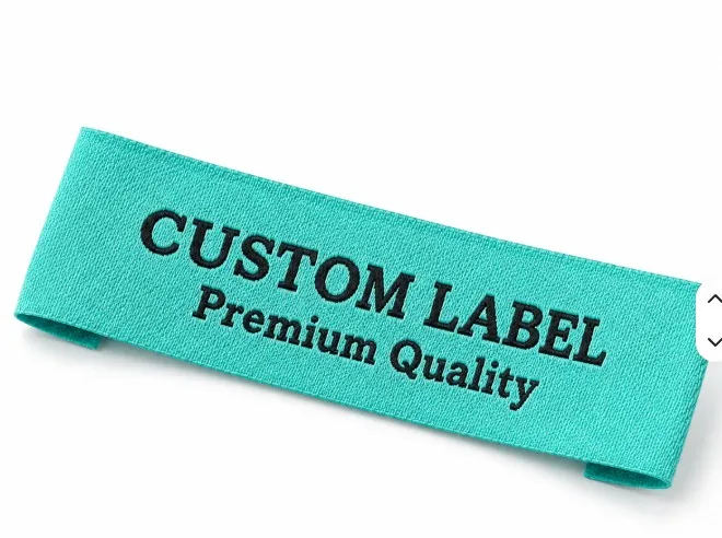 Turquoise custom woven neck label with black CUSTOM LABEL text and folded ends